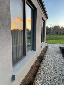 a window on the side of a house with a yard at Guinevere 2 in Myrtleford