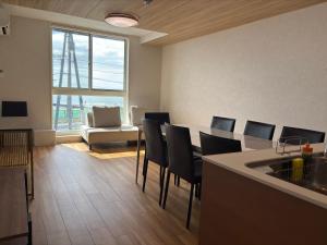 a kitchen with a table and chairs and a large window at Coco Resort Futtsu in Futtsu
