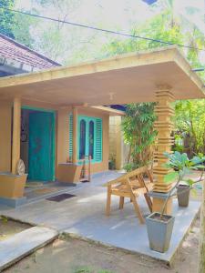 a patio with a bench and a house at Funky Monkey Surfhostel Hiriketiya in Hiriketiya