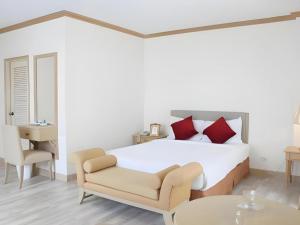a bedroom with a bed and a chair and a table at Romance Hotel Srinakarin in Bangkok +237 photos