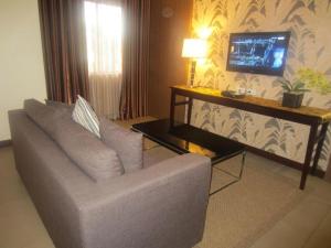 a living room with a couch and a television at GT Hotel Bacolod in Bacolod