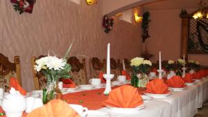 una mesa larga con platos blancos y flores en jarrones en Richzenhainer-Hof, en Waldheim