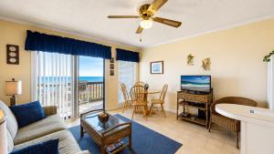 a living room with a couch and a television at Oceanfront 1BR • Updated Balcony • Cherry Grove • Sea Cabin 206-A in Myrtle Beach