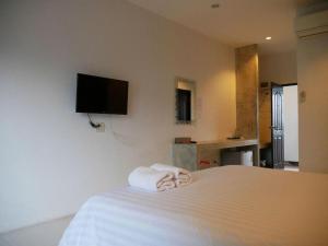 a hotel room with a bed with towels on it at Sabai @ Chumphae Hotel in Chum Phae