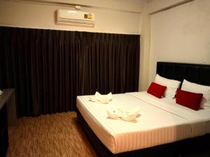 a hotel room with a bed with two towels on it at V51 Hotel in Ban Hua La Loeng