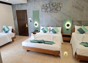 a room with two beds with green and white pillows at U Sabai Living Hotel in Patong Beach +72 photos