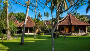 a resort with a green yard with palm trees at mascot hotel senggigi in Senggigi
