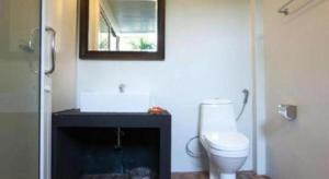 a bathroom with a toilet and a mirror on the wall at Baan Kula Mahasarakam in Ban Nong Chik +84 photos