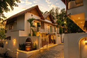 a villa with a gate in front of a house at Ayana Lake Resorts in Kovillūr