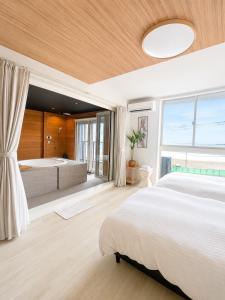 a bedroom with a large bed and a bath tub at Coco Resort Futtsu in Futtsu