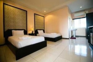 a hotel room with two beds and a television at Pharadhevi in Ban Dung +29 photos