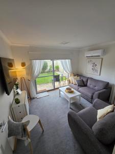 a living room with a couch and a table at Queen bed apartment- No sharing, your very own space in Quinns Rocks