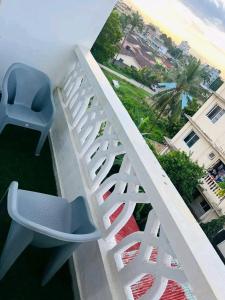 a white railing with a blue chair on a balcony at JKIA Prestige kenya in Nairobi