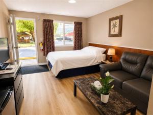 a hotel room with a bed and a couch at Overlander Motel in Chase