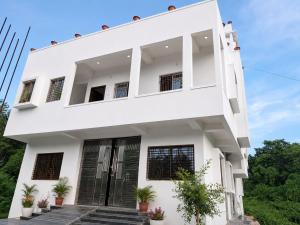 a white house with stairs in front of it at PRANSHI HOMe STAY in Deoghar