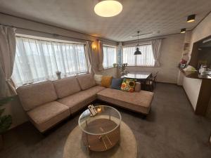 a living room with a couch and a table at T'S House Numazu in Numazu