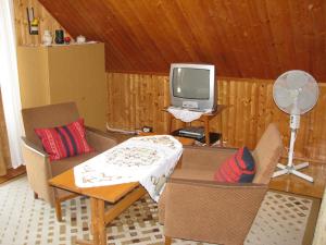 een woonkamer met een tafel en een televisie bij Ottó Nyaraló in Révfülöp