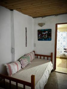 a bed in a bedroom with a wooden ceiling at Tano in Villa Gesell