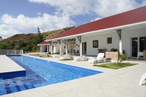 a villa with a swimming pool and a house at Grande villa avec piscine et jacuzzi, vue mer splendide, proche des plages de Grand Anse et de l'Anse Rodrigue, très calme, sans vis-à-vis in Terre-de-Haut