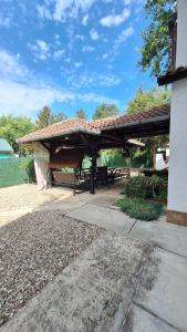 a pavilion with a picnic table and the water at Palić Libero Apartman in Palić