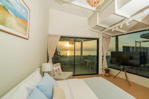 a bedroom with a bed and a large window at Sea Salt Stay Samui in Nathon