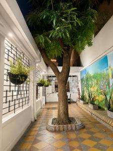 a tree in the middle of a hallway with plants at Hotel Medellin in Santa Marta