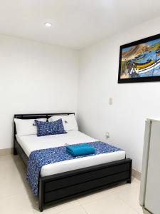 a bedroom with a bed with blue pillows on it at Hotel Medellin in Santa Marta