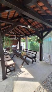 a picnic table and a bench under a pavilion at Palić Libero Apartman in Palić