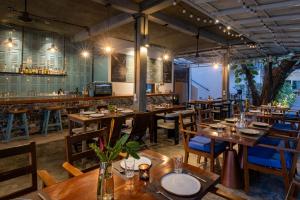 a restaurant with wooden tables and chairs and a bar at Pippali Boutique Hotel in Kampot