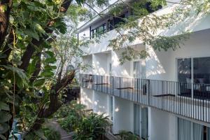 an external view of a white building with trees at Pippali Boutique Hotel in Kampot