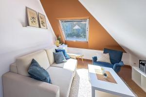 a living room with a white couch and blue chairs at Gästehaus Maria Rast in Suderburg