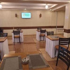 a restaurant with tables and chairs and a sign on the wall at Claire de Lune Moonlight Hotel in Nakuru