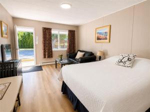 a bedroom with a large bed and a couch at Overlander Motel in Chase