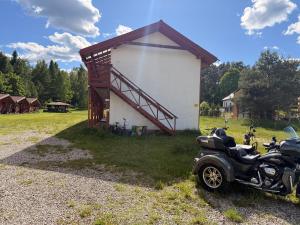 a motorcycle parked in front of a small building at Eco domki Mazury in Ruciane-Nida