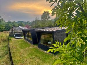 a black house in the middle of a field at WiNGS Retreat in Lupşa