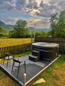 a wooden deck with a hot tub and a chair at WiNGS Retreat in Lupşa +9 photos