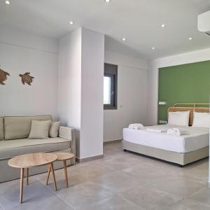 a bedroom with a bed and a couch at Kipos Suites Nidri Lefkada in Nydri