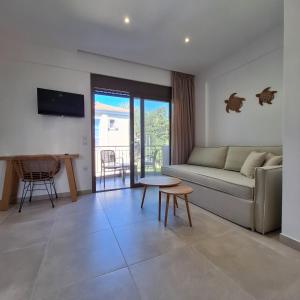 a living room with a couch and a table at Kipos Suites Nidri Lefkada in Nydri