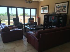 a living room with couches and a tv and windows at Hilken Lodge in Durban