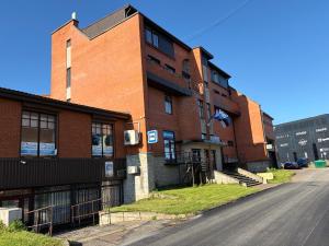 a brick building on a street next to a road at Narva Center Aparthotel in Narva