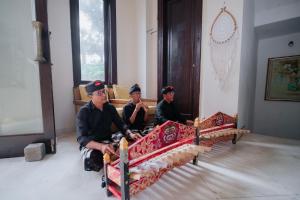 three men sitting on a bench in a room at Anhera Suite Ubud in Ubud +48 photos