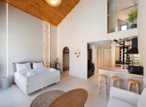 a living room with a white couch and a kitchen at Anamu Suites in Kondáraina
