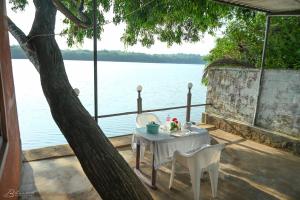 a table and chairs sitting next to the water at Sattva camps and cottages - Udupi in Udupi +16 photos