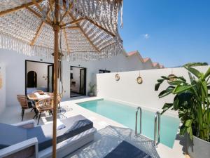 a villa with a swimming pool and a table and chairs at Anamu Suites in Kondáraina