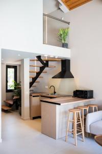 a kitchen with a sink and a counter with stools at Anamu Suites in Kondáraina