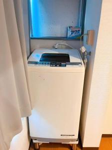 a washing machine in a room with a window at Youki Residence in Tokyo