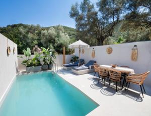 a patio with a table and chairs next to a pool at Anamu Suites in Kondáraina