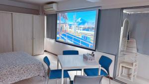 a bedroom with a table and chairs and a tv at Youki Residence in Tokyo