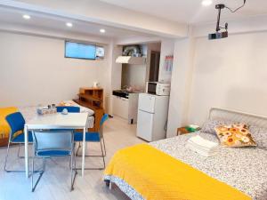 a bedroom with a bed and a table and a kitchen at Youki Residence in Tokyo