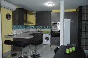 cocina con encimera y fogones horno superior en LyriosHomes Apartamentos Los Tréboles, en Málaga